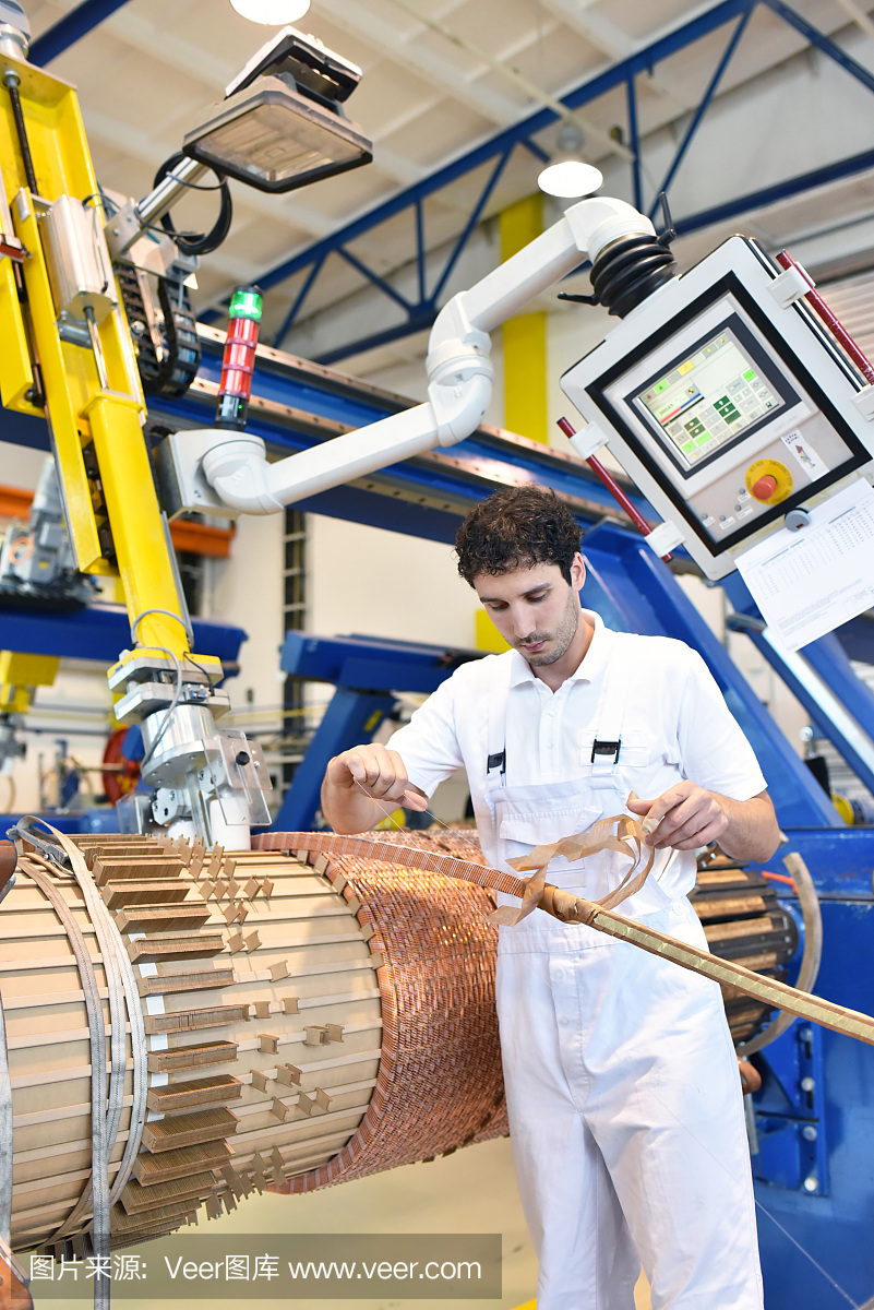 在一家工厂里,年轻的机械工程工人正在操作一台绕铜线的机器——制造变压器